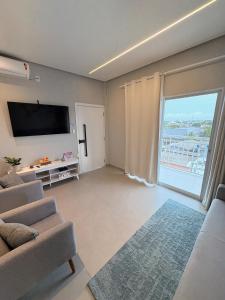 a living room with a tv and a large window at Modern apartment, with excellent location in Macapá