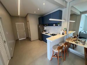 a kitchen with blue cabinets and a table and chairs at Modern apartment, with excellent location in Macapá