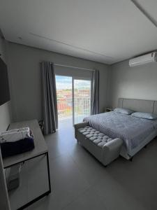 a bedroom with a bed and a large window at Modern apartment, with excellent location in Macapá