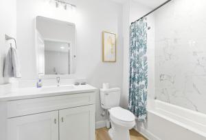 a bathroom with a sink and a toilet and a shower at Chic 3BR, 2BA -Brand New! in Englewood +24 photos