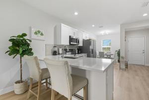 a kitchen with white cabinets and a potted plant at Chic 3BR, 2BA -Brand New! in Englewood
