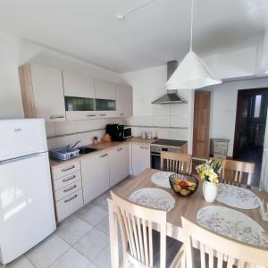 a kitchen with a table and chairs and a white refrigerator at Apartment Drejca in Kobarid