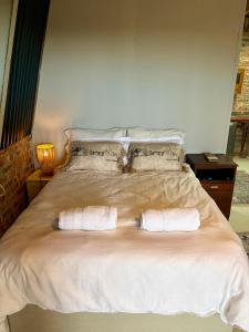 a bedroom with a bed with two towels on it at Esperanza Dira's in George