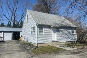a white house with a garage and a driveway at Sunnyside Rental-Entire vacation home 3 Bedroom 2 Bathrooms 1 Kitchen in McHenry