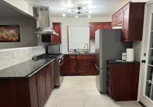 a kitchen with wooden cabinets and a stainless steel refrigerator at Sunnyside Rental-Entire vacation home 3 Bedroom 2 Bathrooms 1 Kitchen in McHenry