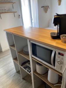 a kitchen with a table with a microwave on it at Cassis et ses trésors in Cassis