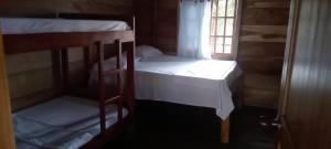 two bunk beds in a room with a window at Cabaña los recuerdos de ella in Moñitos