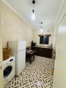 a kitchen with a refrigerator and a washer at CozyQ Apt in Aqaba