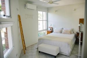 a bedroom with a bed and a chair and windows at AMADO-Un sueño in Junín +6 photos