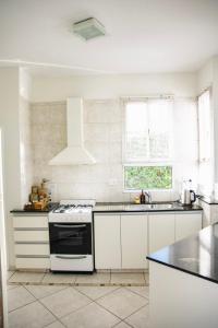 a white kitchen with a stove and a sink at AMADO-Un sueño in Junín