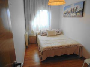 a small bedroom with a bed and a window at Piso ESPAZ in Isla de Arosa