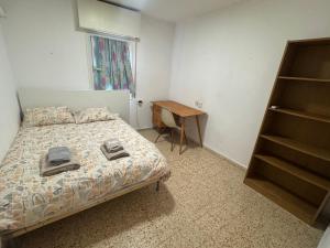 a bedroom with a bed and a desk and a window at צימר הר הגמל in Mitzpe Ramon