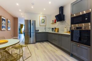 a kitchen with stainless steel appliances and a table at Luxury 1BR Seafront Apartment in Cardiff