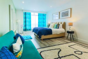 a bedroom with a bed and a couch at Luxury 1BR Seafront Apartment in Cardiff