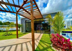 a house with a wooden pergola next to a pool at Conforto103 in Caruaru