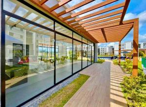 an external view of a building with a wooden pergola at Conforto103 in Caruaru