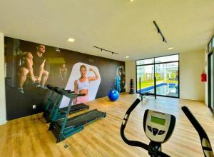 a fitness room with a gym with a treadmill at Conforto103 in Caruaru