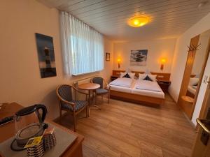 a hotel room with a bed and a table and chairs at Hotel Zum Hanseaten in Borkum