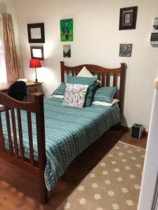 a bedroom with a bed with a green comforter at Knowles Nook Self-catering in Klerksdorp