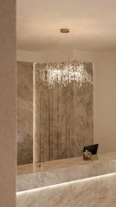 a chandelier in a room with a desk with a laptop at Hotel Donia Sfax in Sfax