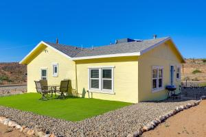 a yellow house with a table and chairs in front of it at Route 66 Roadtripper Retreat w/ Private Backyard in Kingman