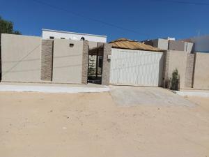 ein Haus mit einem weißen Tor und einer Auffahrt in der Unterkunft Djerba Aldo Piscine in Houmt Souk