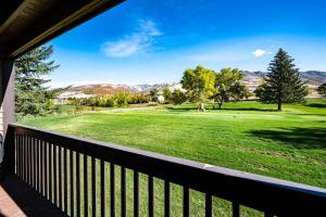 a view from a porch of a golf course with mountains in the background at Luxuriously Contemporary Condo WL1401 Powder Mtn in Eden