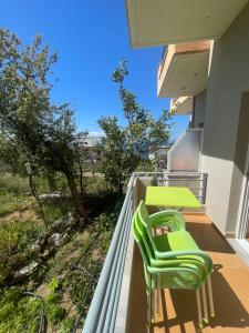 a balcony with two green chairs and a table at Bleta Residence in Sarandë +19 photos