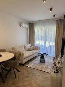 a living room with a couch and a table at Casella Apartment E34 Let's Sea Baltic Park in Gąski