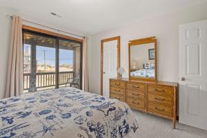 a bedroom with a bed and a dresser and a mirror at Ocean Views From Every Room in Kitty Hawk