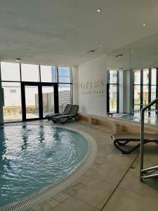 a large swimming pool with chairs in a building at Casella Apartment E34 Let's Sea Baltic Park in Gąski