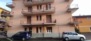 two cars parked in front of a building at Alloggio Tommy in Biella