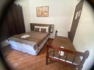a small bedroom with a bed and a bench at Vale do Pontal Angra Suites in Angra dos Reis