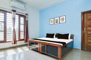 a bed in a room with a blue wall at Hotel O KLER Guest House in Kharar