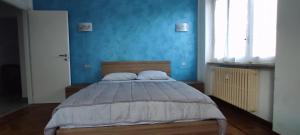 a bedroom with a bed with a blue wall at Alloggio Tommy in Biella