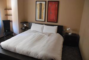 a bed with white sheets and pillows in a bedroom at Residence Corona Grossa in Ciriè