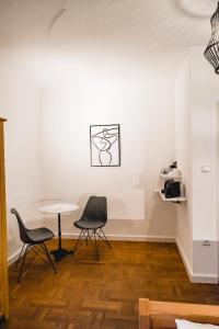 two chairs and a table in a room with white walls at KOKORO am Kirchplatz in Sankt Veit am Vogau