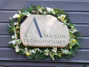 a sign on the side of a building with a wreath at Maison Tronchiennes in Durbuy