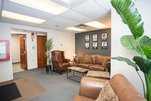 a waiting room with a couch and chairs and a table at Wardens Quarters: 2 Bedroom Apt in Sault Ste. Marie