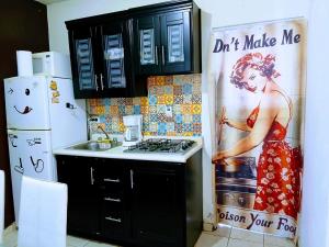 a kitchen with a poster of a woman on the wall at Tu hogar ideal, cómodo, acogedor y único in Los Mochis