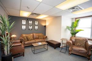 a waiting room with leather couches and a table at Wardens Quarters: 2 Bedroom Apt in Sault Ste. Marie