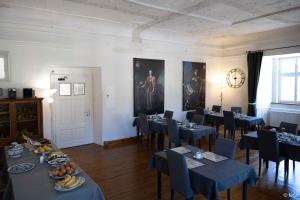 a dining room with tables and chairs and a clock at Hotel im Stift Neuberg in Neuberg an der Mürz