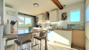 a kitchen with a table and some chairs in it at VILLA EN PROVENCE AVEC PISCINE AU CALME À ARLES - Camargue in Arles