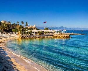 a view of a beach with a pier and the ocean at Cap et Soleil Peaceful Private Garden, 2 Terraces, Pool, Garage, 5 Min Walk to Beach in Antibes