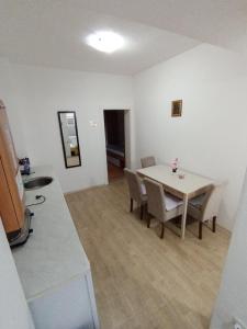 a dining room with a white table and chairs at Apartman TATTOO R in Negotin