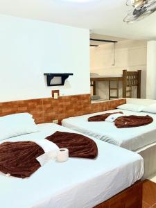 two beds in a room with brown blankets at Hotel Sol y Luna 1 in Medellín