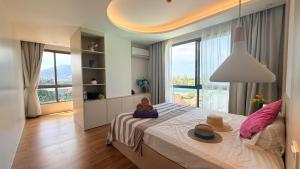 a bedroom with a bed with hats on it at 2BR Fantasea condo kamala in Kamala Beach +25 photos
