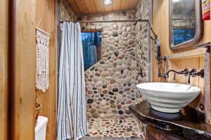 a bathroom with a sink and a stone wall at Big Bear Falls in Ellijay +24 photos