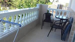 a balcony with two chairs and a table and a fence at Apartment Mixail in Agios Nikolaos