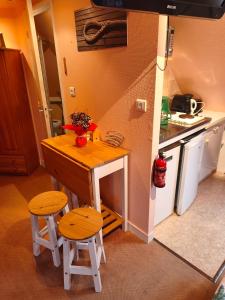 a small kitchen with a small table and two stools at Studio charmant in Fouesnant +26 photos